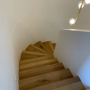 Curved geometric timber staircase viewed from above