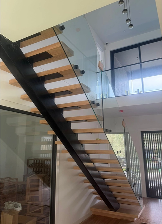 Floating timber staircase with black steel mono stringer