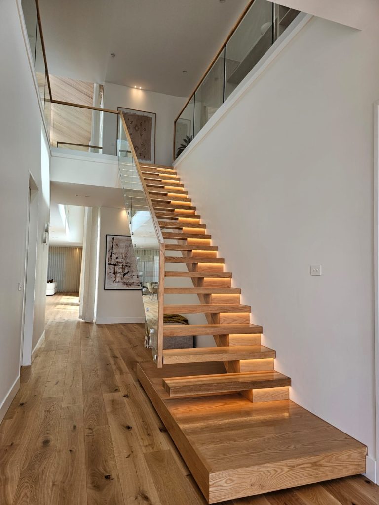 Side mono stringer timber staircase in a modern hallway