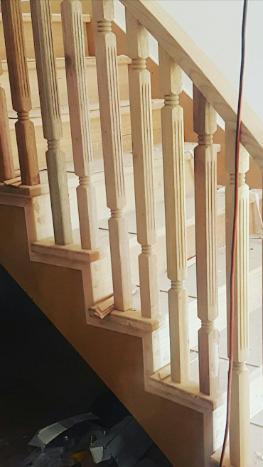 Timber staircase with turned balusters and handrail during installation