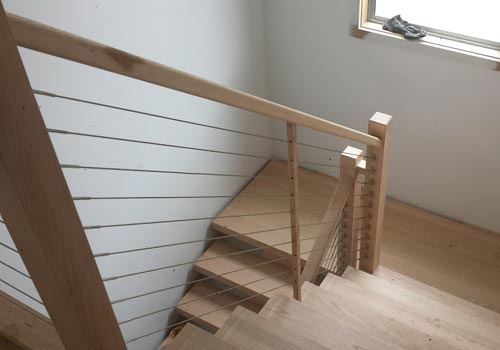 Timber staircase with horizontal wire balustrade and timber handrail