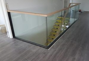 Glass stair balustrade with timber handrail and open stairwell