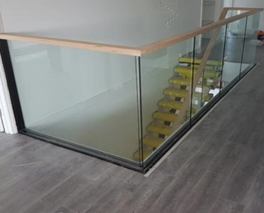 Glass balustrade with timber handrail around a stair opening