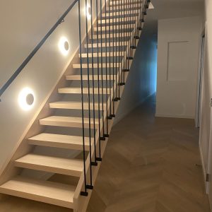 Illuminated townhouse timber staircase with wire balustrade