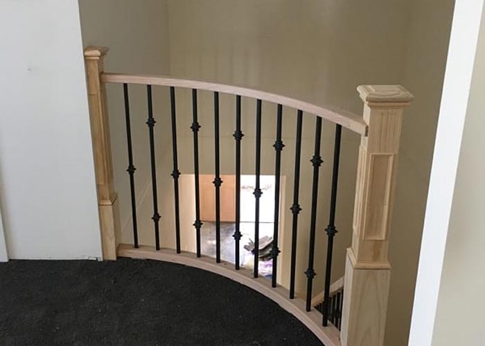 Curved timber staircase with decorative balustrade at an upper landing